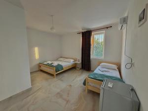 a room with two beds and a tv in it at Lukova rooms in Lukovë