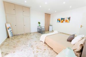 a bedroom with a large bed and a white wall at Casa Antonella in Trabia