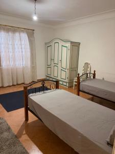 a bedroom with two beds and a window at Villa agamy in Burj al ‘Arab al Jadīdah
