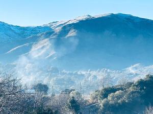 a snow covered mountain in the distance with trees at Casablanca in Huerta Grande