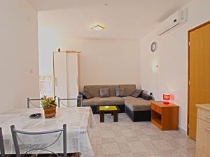 ein Wohnzimmer mit einem Sofa und einem Tisch in der Unterkunft Apartments Orange 768 in Fažana
