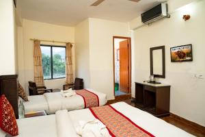 a hotel room with two beds and a television at Admire Hotel Pvt Ltd in Pokhara