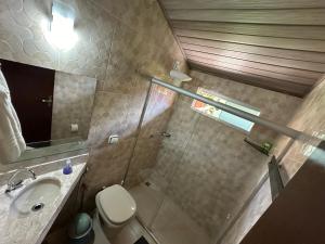 a bathroom with a toilet and a sink and a mirror at Chico de Sá Pousada in Pirenópolis +51 photos