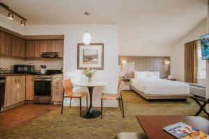 a hotel room with a bed and a table and chairs at Executive Suites Hotel and Resort, Squamish in Squamish