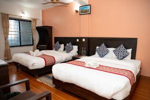 a hotel room with two beds and a window at Admire Hotel Pvt Ltd in Pokhara