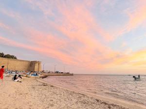 a group of people on the beach at sunset at Vue Mer in Hammamet Nord
