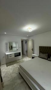 a bedroom with a large white bed in a room at Vue Mer in Hammamet Nord