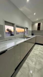 a large kitchen with white counters and windows at Vue Mer in Hammamet Nord