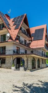 a building with solar panels on the roof at Home Tatra in Biały Dunajec