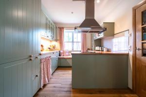 a kitchen with white cabinets and a large window at Ferienhaus WalnutCottage in Rechlin