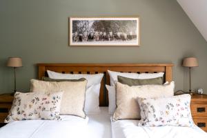 a bedroom with a bed with white sheets and pillows at Ferienhaus WalnutCottage in Rechlin