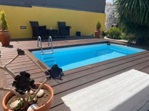 a swimming pool on a wooden deck with a potted plant at Memórias in Nogueira da Regedoura