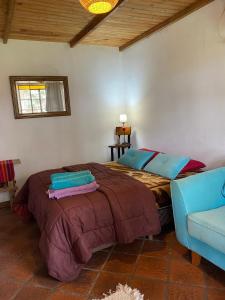 a bedroom with a large bed and a blue couch at Posada Tordillo Hosteria Rural in Chascomús