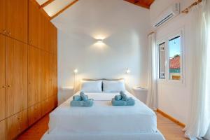 a bedroom with a large white bed with two blue towels at Kooreloo Airy Loft in Koroni