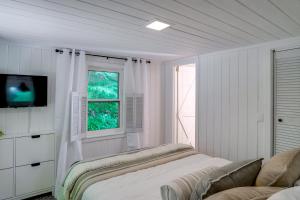 a white room with a bed and a window at High-Design Monroe Cabin on 2 Private Acres! in Readsboro