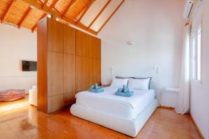 a bedroom with a white bed in a room at Kooreloo Airy Loft in Koroni