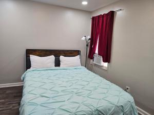 a bed in a bedroom with a red window at Cozy-One in Cincinnati