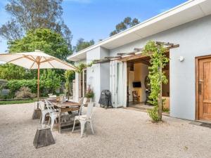 a patio with a table and chairs and an umbrella at Lianna Bungalow in Auburn
