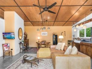 a living room with a couch and a ceiling fan at Lianna Bungalow in Auburn