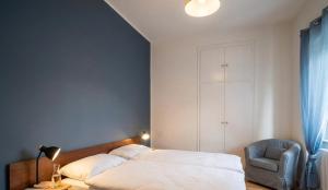 a bedroom with a bed and a chair at Arturs B&B Roveredo in Roveredo