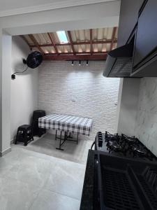 a kitchen with a stove and a table in it at Sobrados Novos Litoral Norte Caraguatatuba, a 150 m a pe da Praia das Palmeiras, Ar condicionado, WiFi gratis, Churrasqueira privativa, Pet friendly, Estacionamento in Caraguatatuba