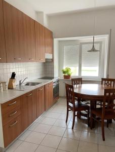 a kitchen with a wooden table and a dining room at Arturs B&B Roveredo in Roveredo +17 photos