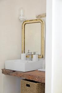 a bathroom with a white sink and a gold mirror at Maison Forte in Montcuq