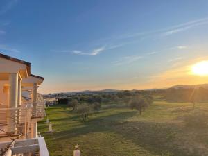 a woman standing on the balcony of a house with the sunset at PoolParadise Tu mejor opción in San Jorge