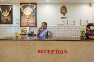 a woman sitting at a counter talking on a cell phone at Hotel O Anu Grand in Visakhapatnam +34 photos