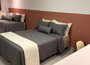a hotel room with two beds and a couch at Oásis urbano in Muriaé