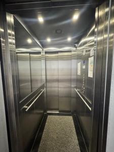 a elevator corridor in a building with stainless steel walls at Oásis urbano in Muriaé +6 photos