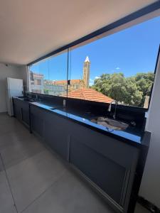 a large window in a kitchen with a large aquarium at Oásis urbano in Muriaé