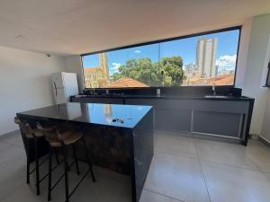 a kitchen with a counter and a large window at Oásis urbano in Muriaé