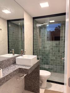 a bathroom with a sink and a toilet and a shower at Oásis urbano in Muriaé