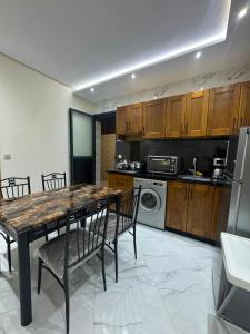 a kitchen with a table and chairs and a microwave at Résidence Maryam in Nador +8 photos