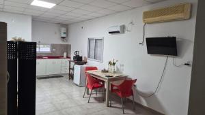 a kitchen with a table and chairs and a television at Punto de Encuentro in Presidencia Roque Sáenz Peña
