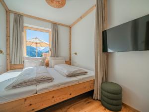 a bedroom with a bed with a flat screen tv at Premium XL in Hollersbach im Pinzgau