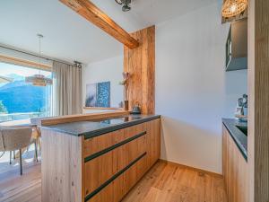a kitchen with wooden cabinets and a counter top at Premium Apartment Almrausch in Hollersbach im Pinzgau