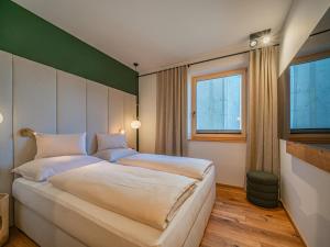 a bedroom with a large bed and a window at Premium Apartment Almrausch in Hollersbach im Pinzgau