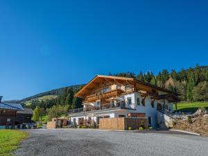 a large house on a hill with a mountain at Premium Apartment Almrausch in Hollersbach im Pinzgau