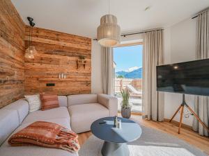 a living room with a couch and a flat screen tv at Premium Apartment Almrausch in Hollersbach im Pinzgau