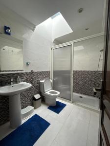 a bathroom with a toilet and a sink and a shower at Chez Bouchra Suite familiale in Pont Blondin +5 photos