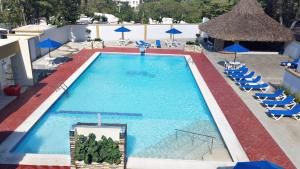 an overhead view of a swimming pool with chairs and umbrellas at Matum Hotel & Casino in Santiago de los Caballeros