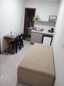 a living room with a table and a brown ottoman at Pousada Ferreira TJ - AP 02 in Cesário Lange
