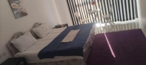 a bedroom with a large bed with a blue blanket at Alkhuwir AlsumouTower in Muscat