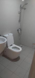 a white bathroom with a toilet and a sink at Alkhuwir AlsumouTower in Muscat