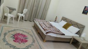 a bedroom with a bed and a table and chairs at Alkhuwir AlsumouTower in Muscat