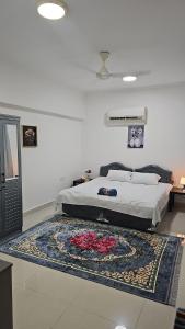 a bedroom with a bed with a rug on the floor at Alkhuwir AlsumouTower in Muscat