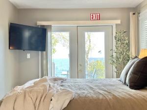 a bedroom with a bed with a exit sign on the wall at Waterfront 22' Windows Starlink Kayaks in Tobermory