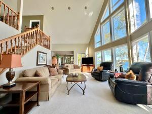 a large living room with couches and a staircase at Waterfront 22' Windows Starlink Kayaks in Tobermory